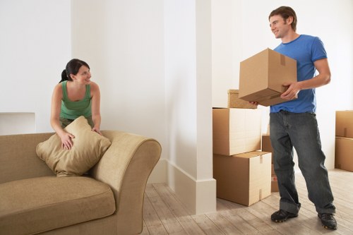 Local movers handling furniture in a Queens Park residential street